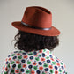 Woman wearing a rust coloured felt fedora