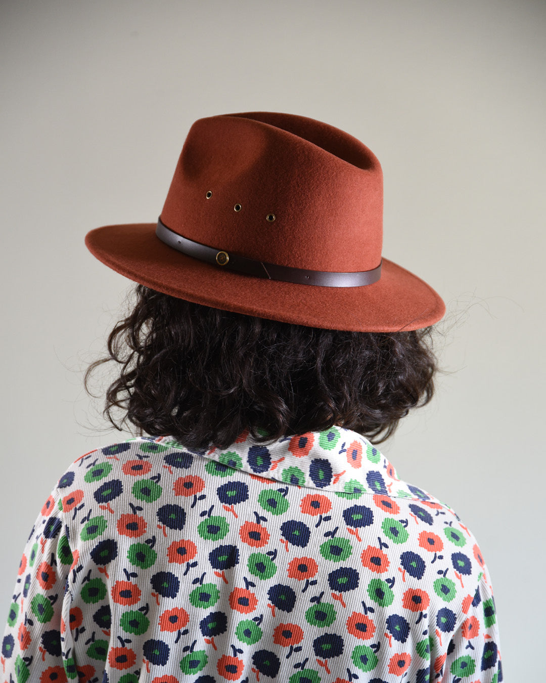 Woman wearing a rust coloured felt fedora