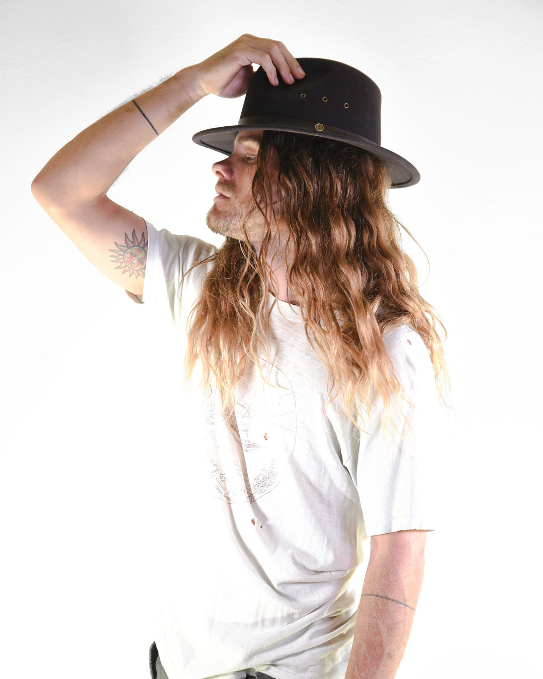 Person wearing a black hat and white t-shirt against a white background