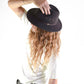 Person wearing a black hat with a white background