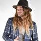 Man wearing a black hat and blue checkered jacket on a white background