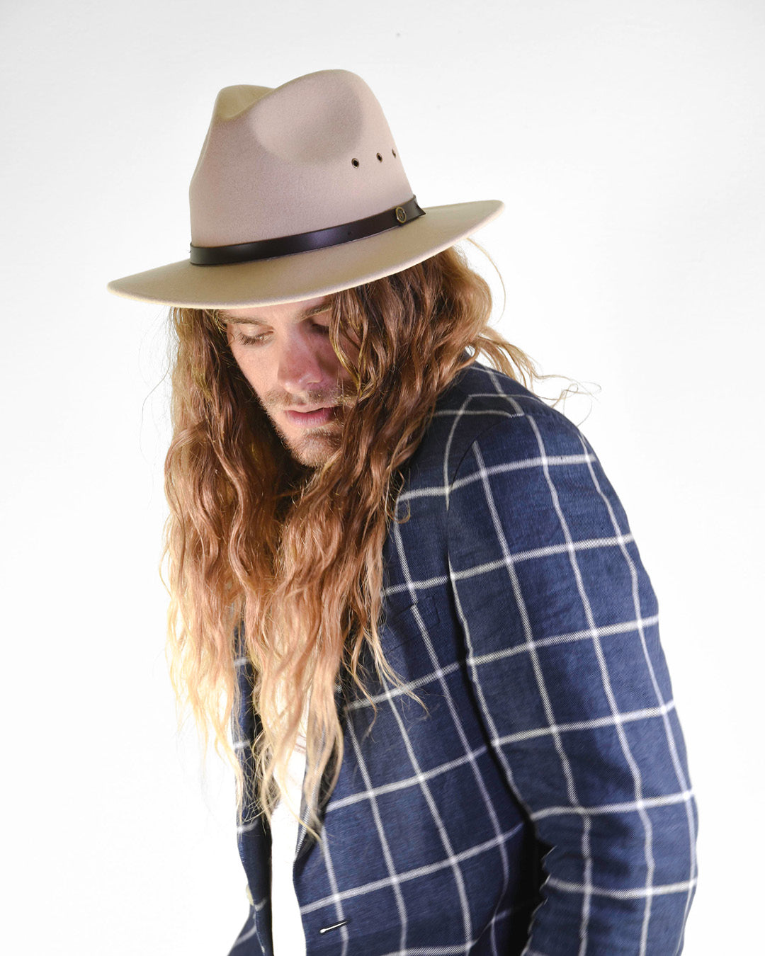 man wearing wool felt hat on grey background