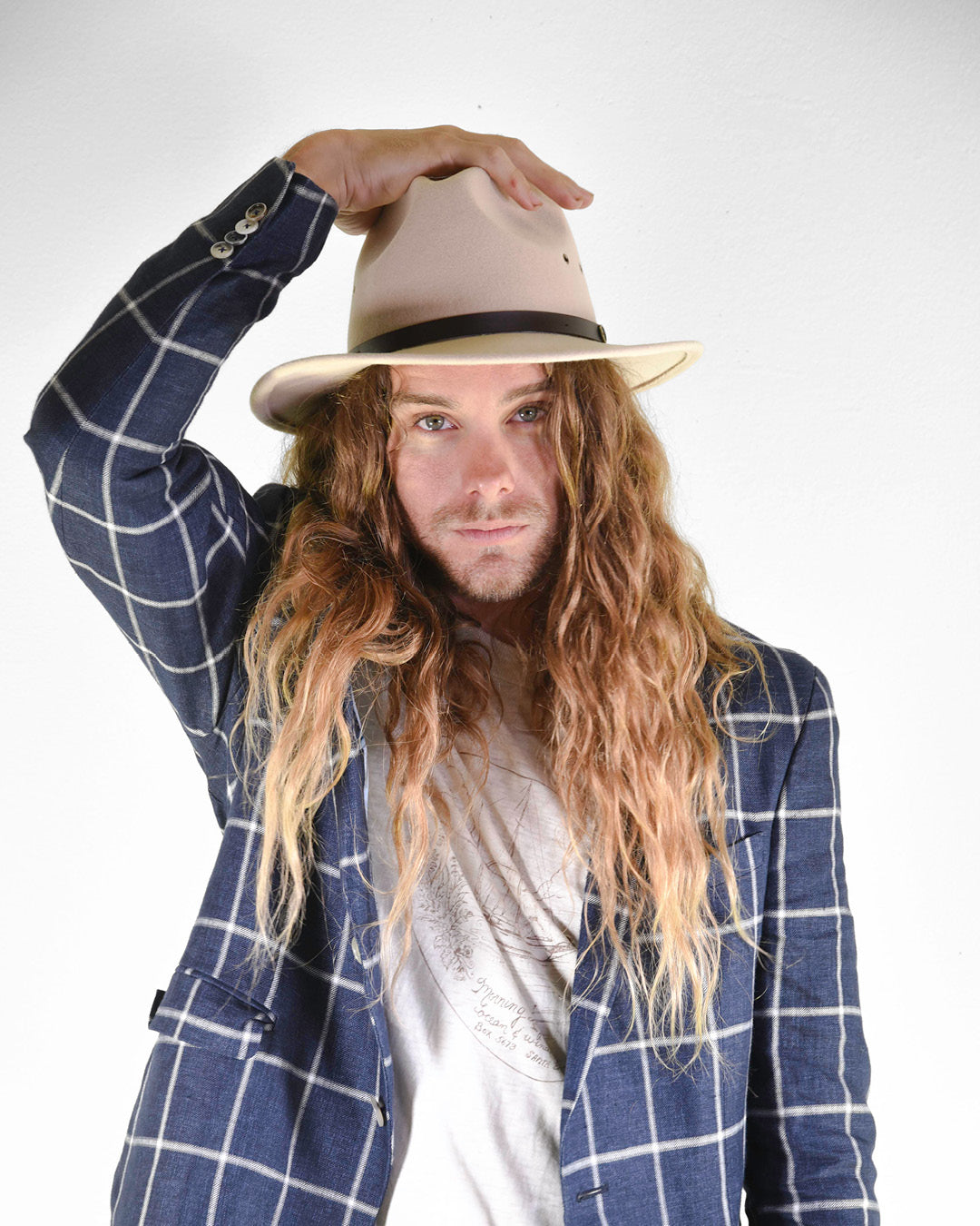 Man looking forward wearing wool felt hat in a cream colour