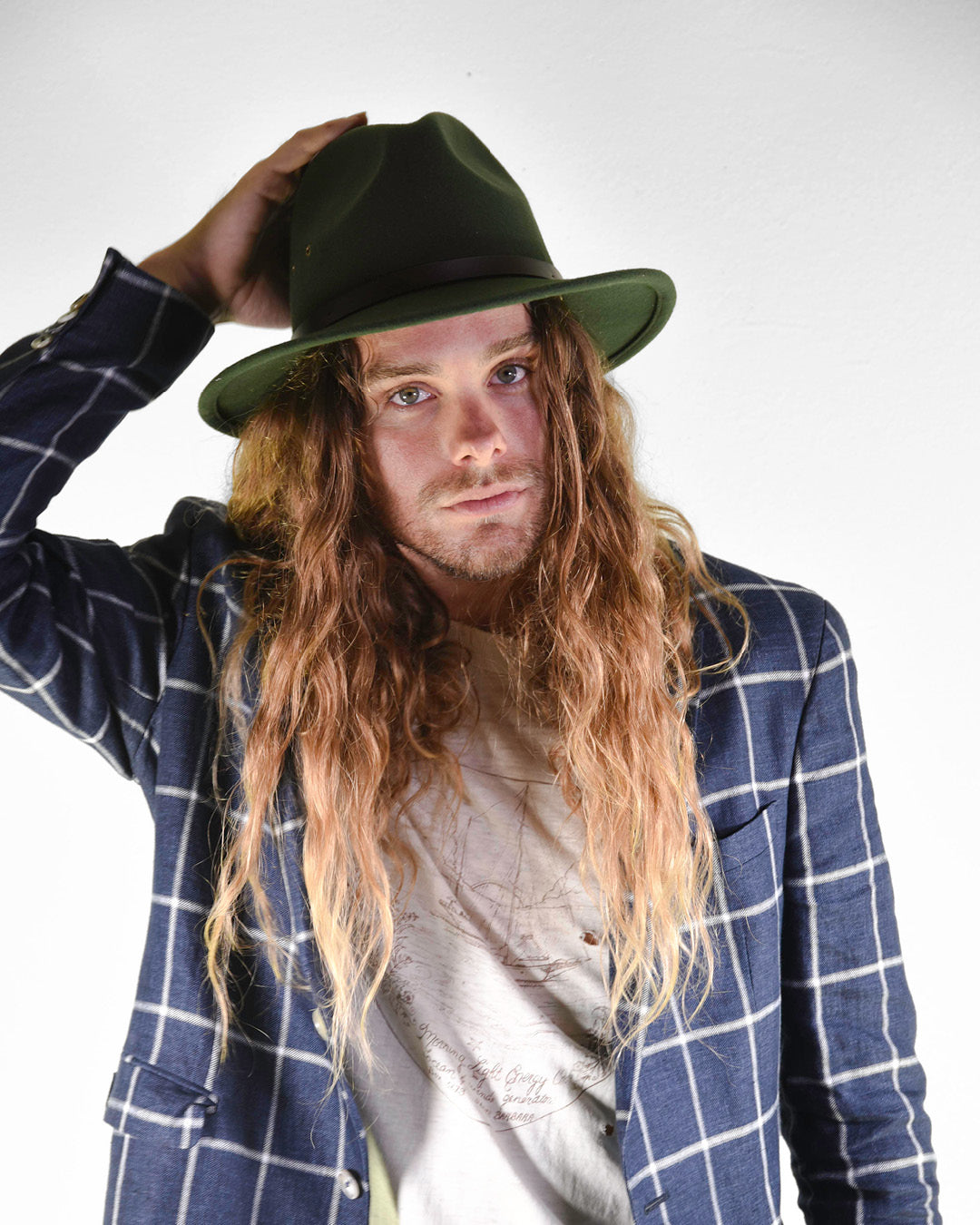 Man in a forest green wool felt hat and blue jacket