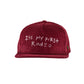 Front view of a wine red corduroy cap with “It’s My First Rodeo” embroidered in white.