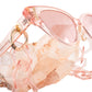 Detail shot showing the glasses attached to the chain among natural crystal props and soft shadows

