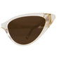 Macro detail of the amber-tinted lenses and frame curvature. Polarised lenses are framed in glossy clear acetate, giving a glowing and luxurious look to these statement cat-eye sunglasses.

