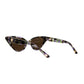 Overhead angled view of The Astral Plane sunglasses showing the strong geometric cat-eye frame and warm amber lens tone. A perfect representation of bold femininity with an otherworldly finish.

