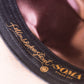 View of the inner hat lining with bronze satin finish and gold-embossed Fallenbrokenstreet x SOMA Byron Bay branding. Reflects elevated craftsmanship and attention to detail.

