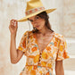 Female model in floral dress wearing mustard festival hat – side angle

