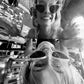 Two women laughing while wearing The Astral Plane – Skywalker/Amber sunglasses. The black-and-white setting adds contrast to the clear frames and gold accents. Playful and lifestyle-oriented.

