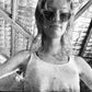 The Astral Plane sunglasses seen on a model centered under natural light with an industrial ceiling above. The cat-eye frame reflects soft lighting, giving a retro sci-fi look.

