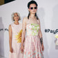 Model wearing The Mischief – Skywalker/Black sunglasses on the runway or event setting, styled with pastel outfit and statement presence.

