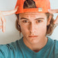 Close-up of man adjusting the red Stingray Pete cap while leaning back.

