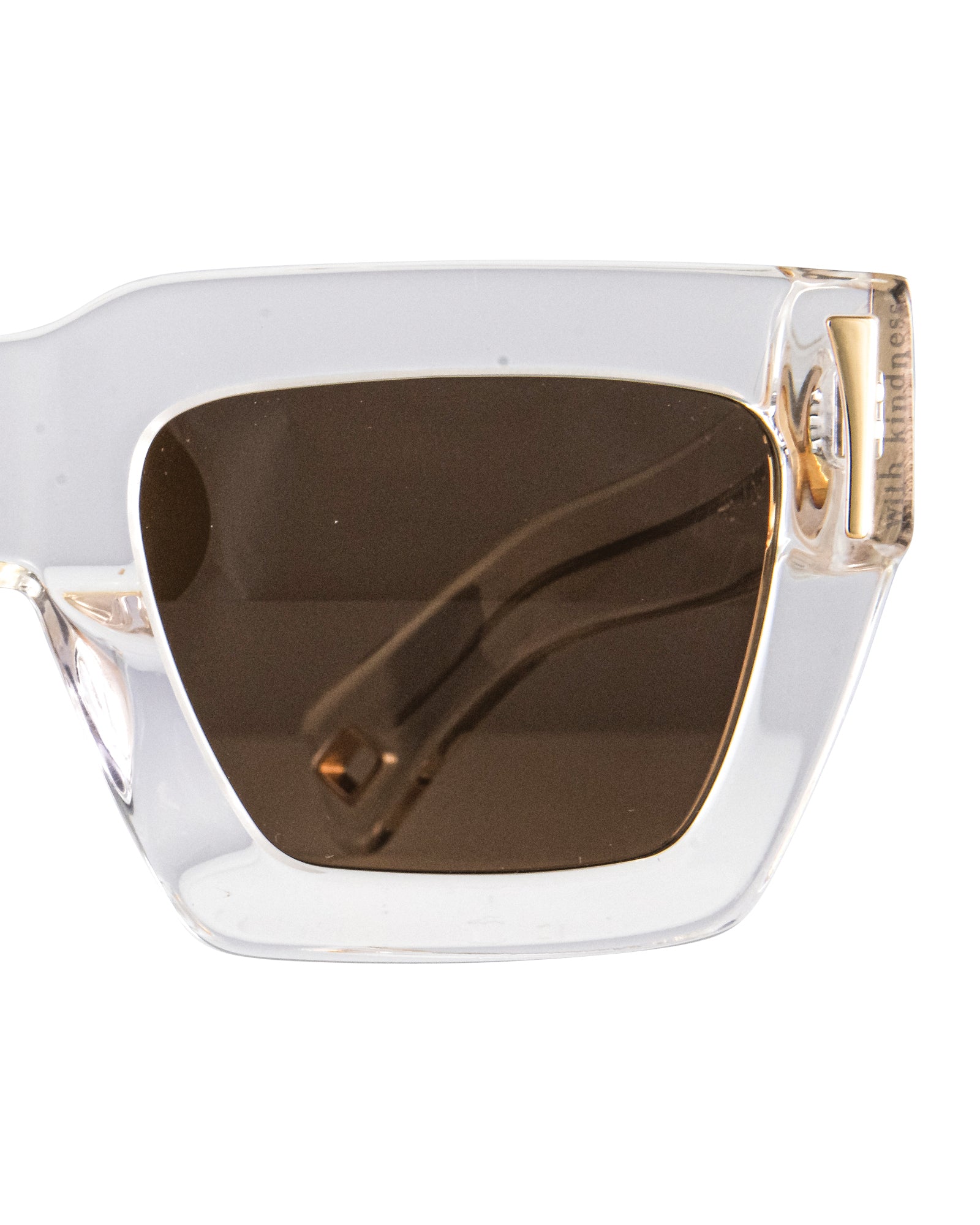 Close-up of the amber CAT2 lens and gold detailing on the white acetate frame. Highlights frame quality, chain loop, and lens tint.

