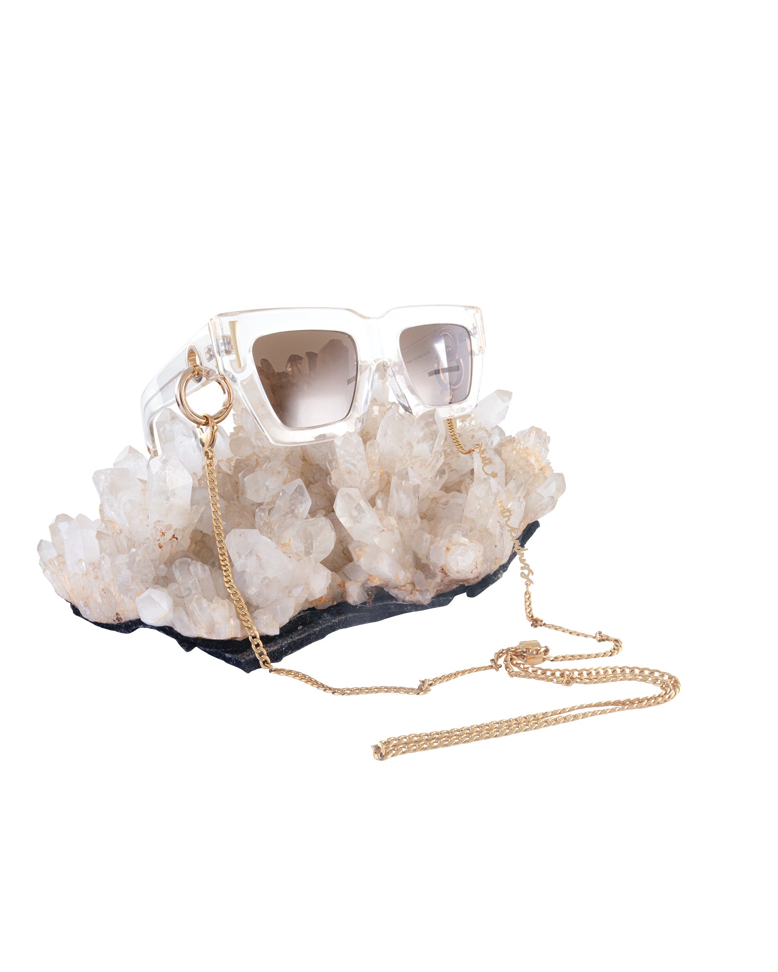 The Mischief sunglasses with amber lenses styled alongside black acetate SUPERNATURAL chain and quartz crystals. Chain sold separately.

