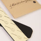 Fallenbrokenstreet hat filler strips displayed with branded kraft tag packaging. Includes one black and one printed cream felt strip with adhesive backing. Perfect for making your favourite hat fit just right, these strips reduce the inner circumference by up to 2.5cm. Designed to be used with wool felt or straw hats, the fillers are easy to apply and remove. Great for styling flexibility and hat stability. The branded packaging adds an artisanal touch, aligning with Fallenbrokenstreet's thoughtful accessor