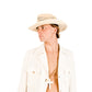 Model wearing The Lover Straw Hat – Natural, styled with a white jacket and open shirt for a fresh, sun-kissed look. The wide brim casts a soft shadow, highlighting its UPF functionality and timeless design perfect for long summer days.

