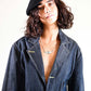 Model wearing The Château Beret styled with a button-down coat, showing timeless cool-weather appeal.


