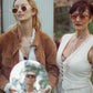 Editorial lifestyle photo of two women wearing THE COSMOS – Pink/Pink sunglasses. Retro styling, standing outdoors, one holding a mirror with a man’s reflection. Playful and cinematic vibe.

