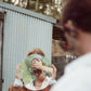 Over-the-shoulder candid shot of two models walking away wearing The Mischief – Galaxy/Pink sunglasses. A sun-drenched, cinematic moment.


